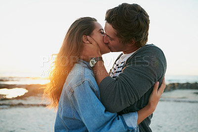 Buy stock photo Shot of an affectionate young couple bonding at the beach