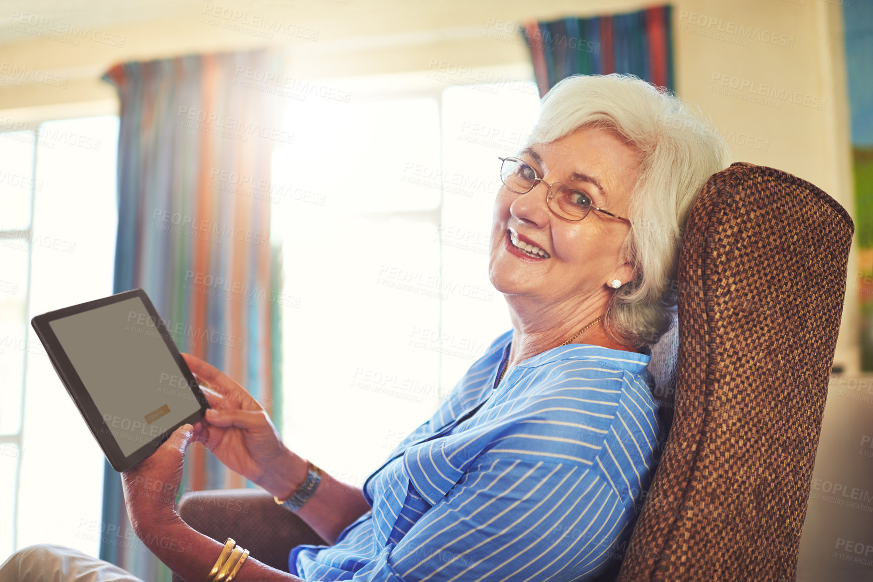 Buy stock photo Cropped shot of a senior woman using a tablet at home