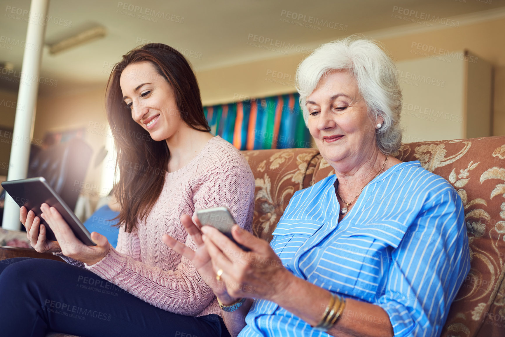 Buy stock photo Elderly woman, grandchild and technology in living room for visit, help or senior care as family. Female people, communication and love in retirement home for weekend on couch together with bonding