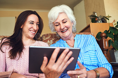 Buy stock photo Cropped shot of a senior woman and her granddaughter using a tablet at home