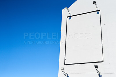 Buy stock photo Poster, mockup space and frame on building in city for advertising, promotion or marketing display. Blue sky, board and blank banner in town for outdoor commercial, announcement or public information