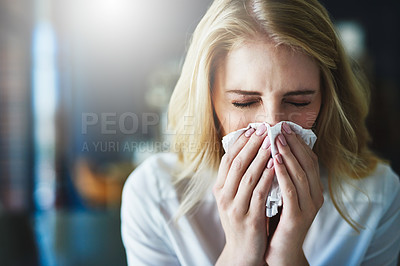 Buy stock photo Shot of a frustrated businesswoman using a tissue to sneeze in while being seated in the office