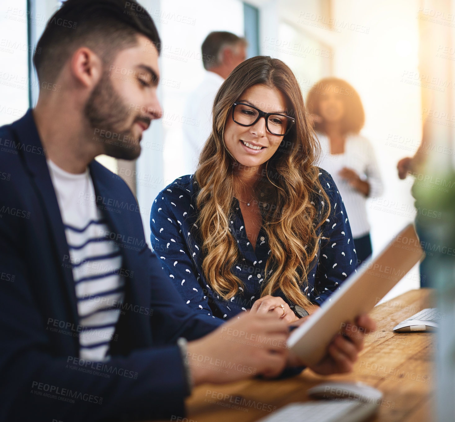 Buy stock photo Shot of colleagues working together on a digital tablet in an office