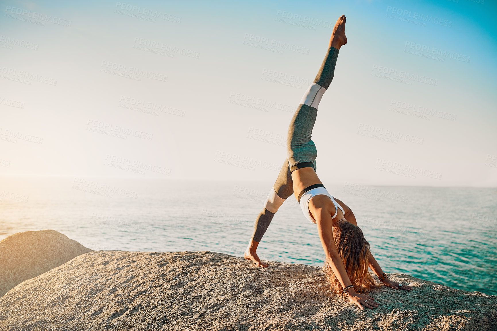Buy stock photo Shot of an athletic young woman practicing yoga on the beach