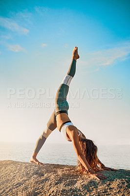 Buy stock photo Shot of an athletic young woman practicing yoga on the beach