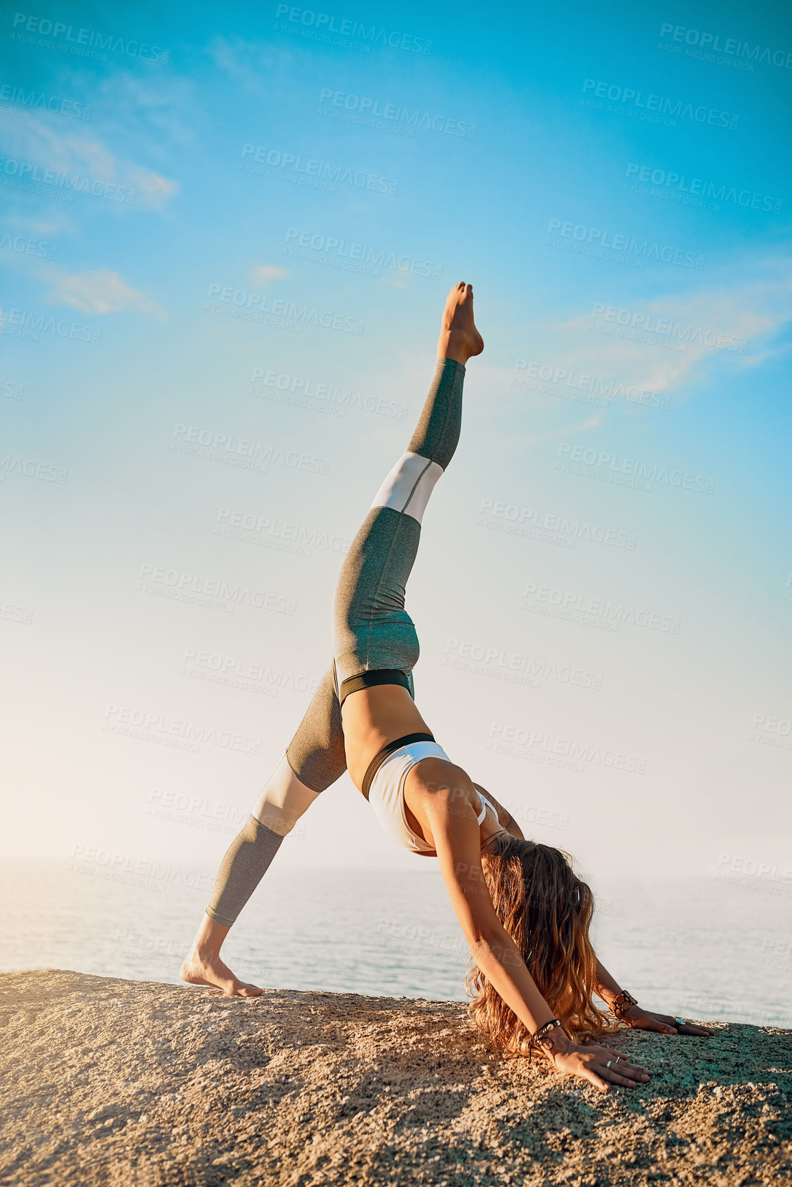 Buy stock photo Shot of an athletic young woman practicing yoga on the beach