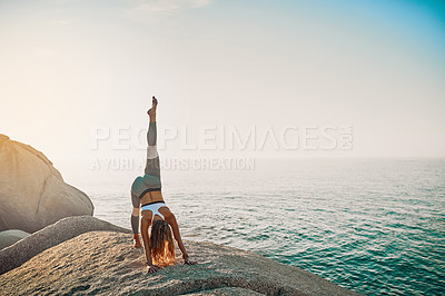 Buy stock photo Shot of an athletic young woman practicing yoga on the beach