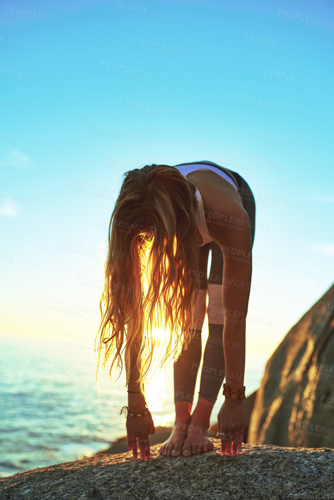 Buy stock photo Shot of an athletic young woman practicing yoga on the beach