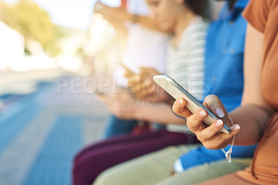 Buy stock photo Shot of a group unrecognizable people using their phones outside during the day