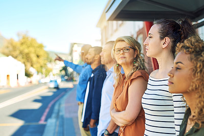 Buy stock photo Shot of a group friends standing and looking into the distance next to a street outside