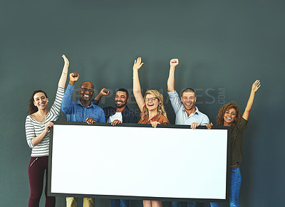 Buy stock photo Excited business people showing a blank sign, promoting a product and giving a message on a board while standing together in an office at work. Portrait of happy colleagues holding an empty poster