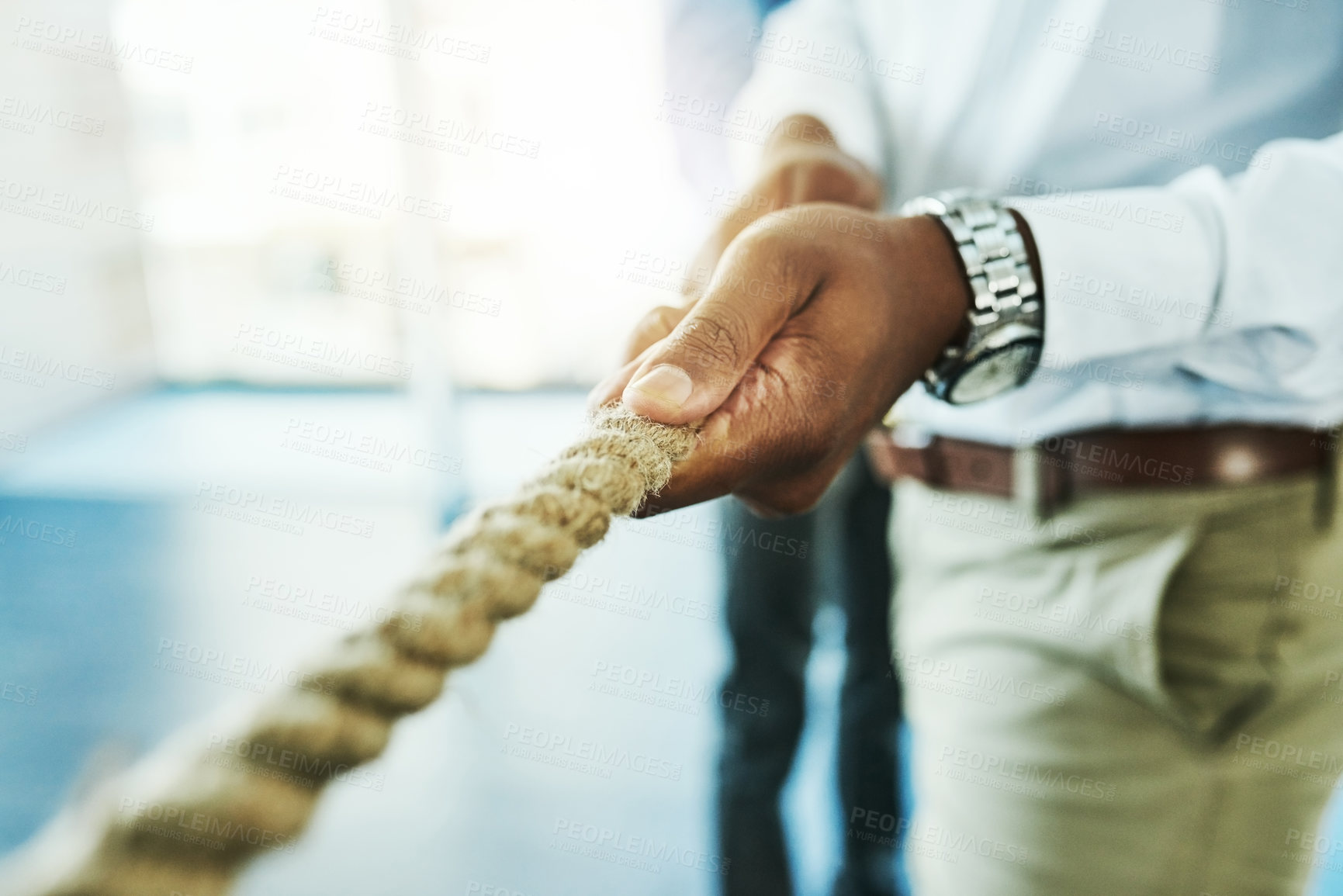 Buy stock photo Shot of an unrecognisable businessman pulling on a rope during tug of war