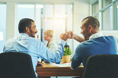Buy stock photo Rear view shot of two businessmen fist pumping in an office