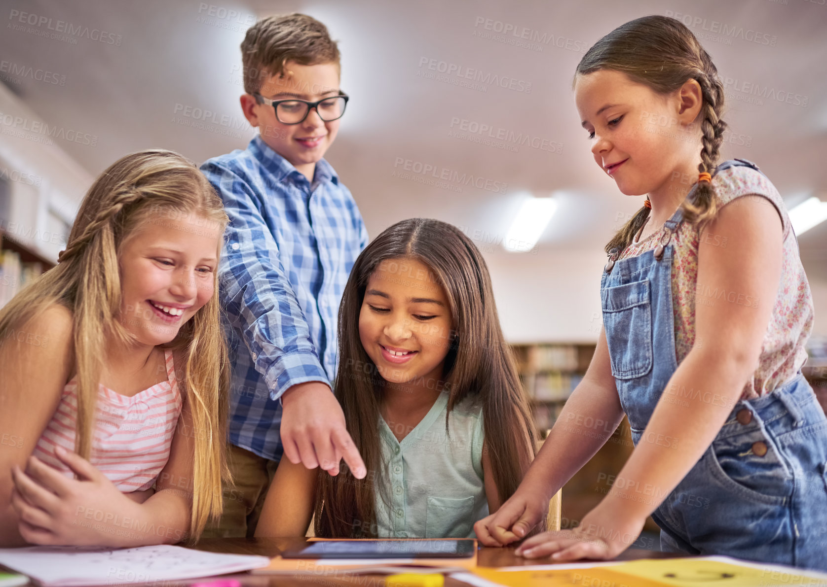 Buy stock photo Shot of a group of young children using a digital tablet at school