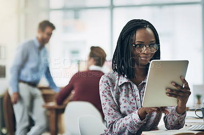 Buy stock photo Shot of a young woman using a digital tablet in a modern office