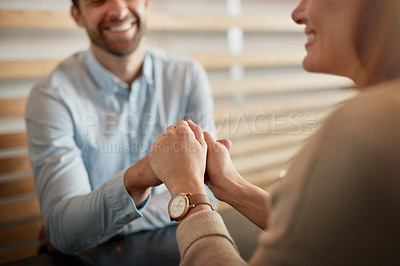 Buy stock photo Shot of an affectionate young couple holding hands while sitting in a cafe