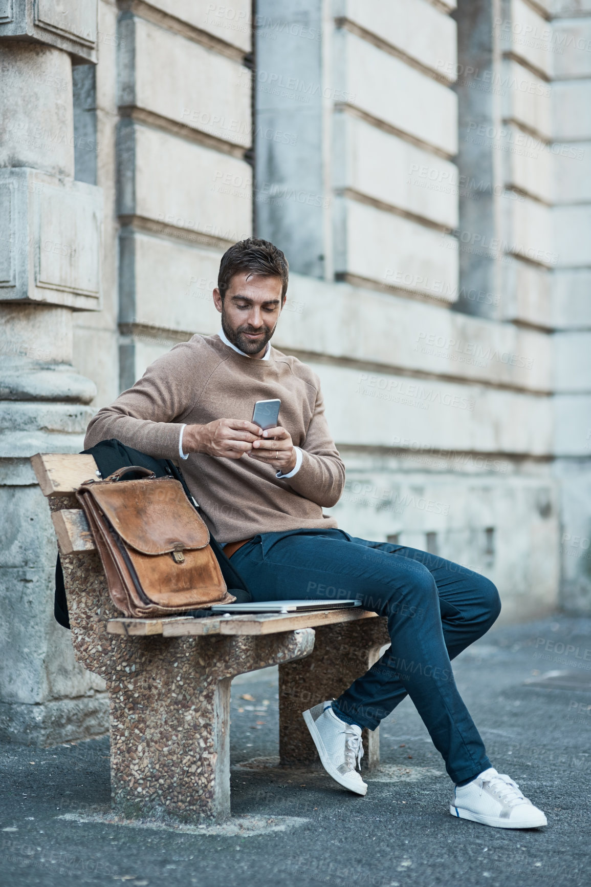 Buy stock photo Businessman, street and happy with smartphone on bench with mobile app for ehailing cab in New York. Male person, employee and smile with networking, communication and connection on social media