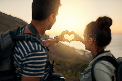 Buy stock photo Cropped shot of a couple forming a heart shape with their hands while out hiking