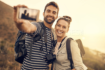 Buy stock photo Shot of a happy couple taking a selfie while out on a hiking trip
