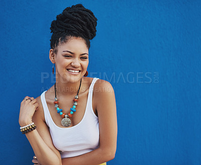 Buy stock photo Studio shot of an attractive and trendy young woman posing against a blue background