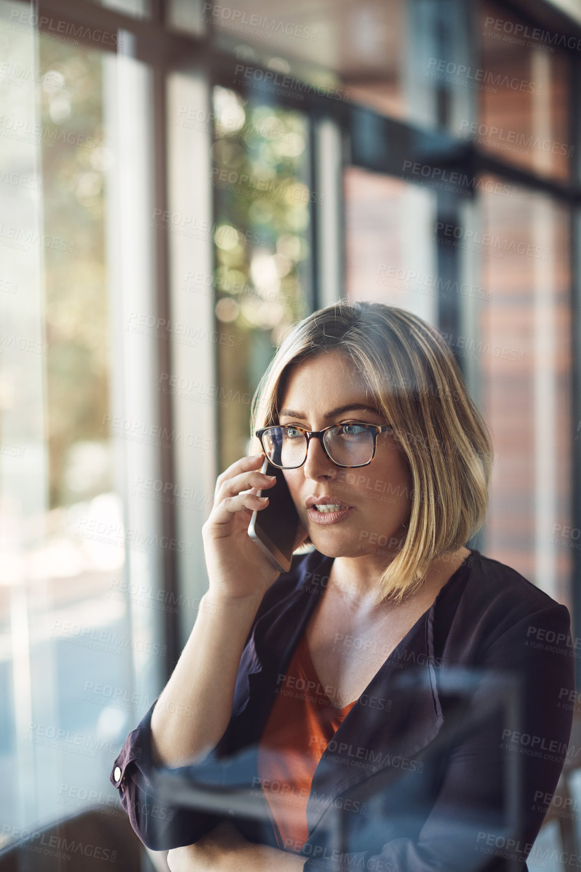 Buy stock photo Young business woman on the phone making a call in a modern office. Female standing alone at work calling on smartphone, talking or speaking to company clients in her workplace