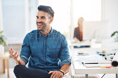Buy stock photo Happy young corporate business man talking, thinking and working at a desk in an office at work. One worker, employee or manager looking cheerful, confident and laughing while sitting at a table