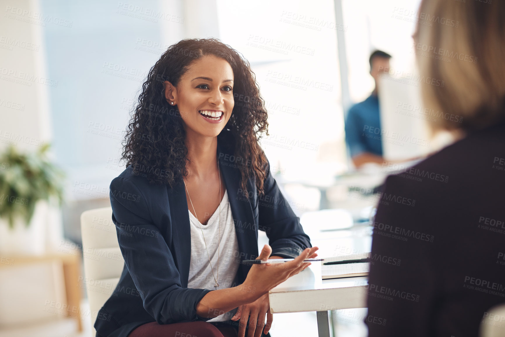 Buy stock photo Shot of two young women having a conversation in a modern office