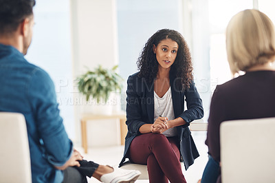 Buy stock photo Shot of a young therapist speaking to a couple during a counseling session