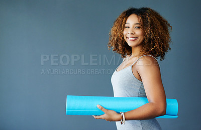 Buy stock photo Cropped shot of a young woman holding a yoga mat against a grey background