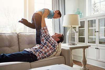 Buy stock photo Father, child and happy on sofa for airplane game, playful and bonding with care, love and laughing in house. Dad, boy and lifting for plane, connection and flight on couch in lounge at family home