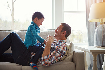 Buy stock photo Playing, family and father with child on sofa for bonding, laughing and relax together on weekend. Happy, home and dad with young boy on couch for playful relationship, love and fun in living room