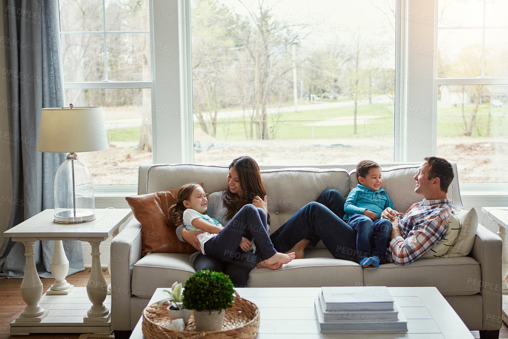 Buy stock photo Love, smile and family on a couch, playing and bonding to relax , home and cheerful on a weekend break. Parents, mother and father with children, kids and happiness with joy, loving and chilling