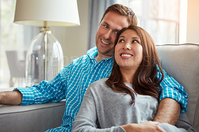 Buy stock photo Shot of a happy young couple relaxing together on the sofa at home