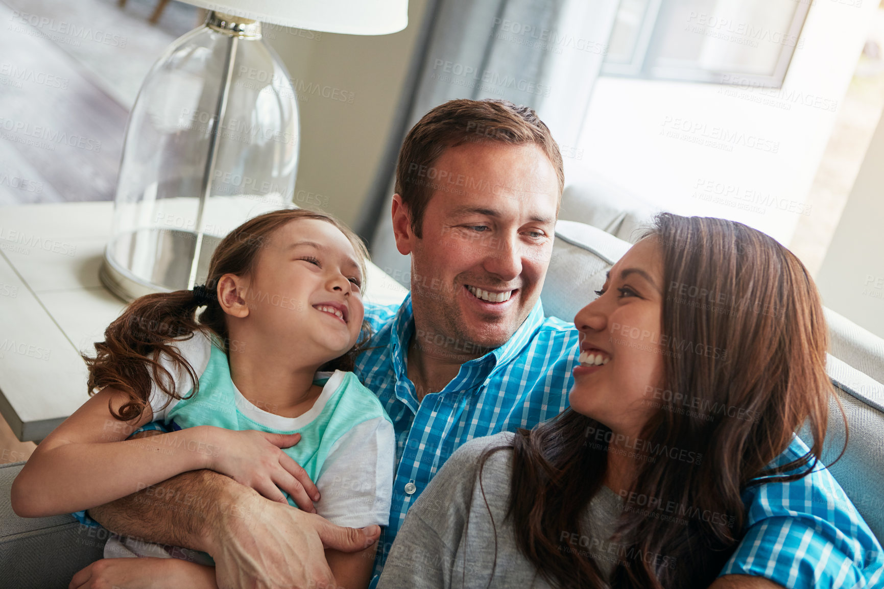 Buy stock photo Love, child and happy family in home with parents together for care, relax and bonding. Kid, mother and father on sofa for support, conversation and healthy relationship with girl in living room