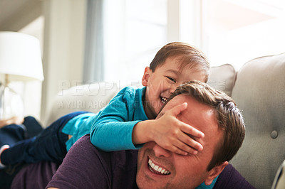 Buy stock photo Laugh, playing and father with child on sofa for bonding, funny and relax together on weekend. Family, home and happy dad with boy cover eyes for fun relationship, love and peekaboo in living room