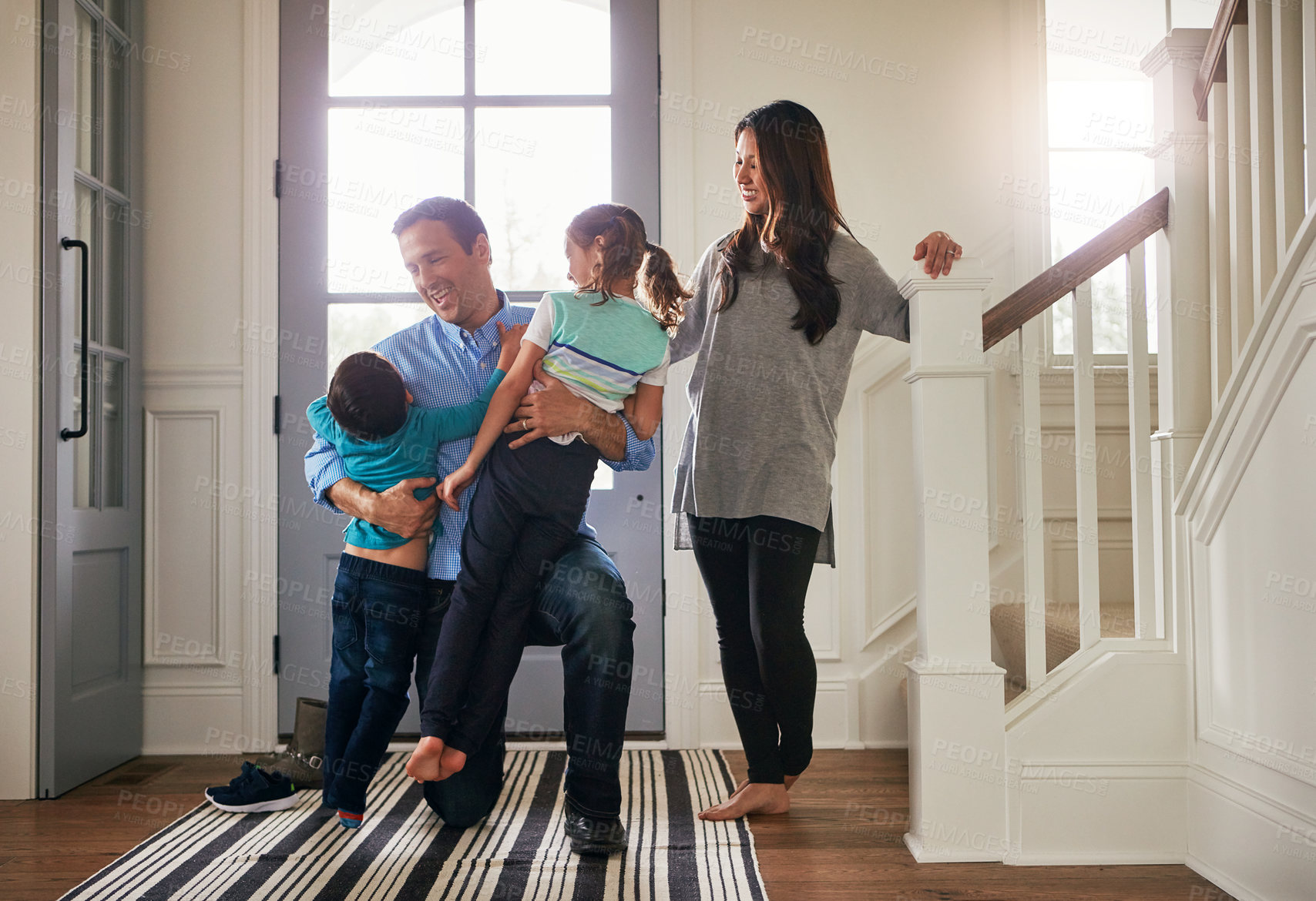 Buy stock photo Home, front door and father with children hug for greeting, welcome and excited for return. Family, hello and happy mother, dad and kids in house embrace for affection, relationship and bonding