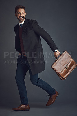 Buy stock photo Studio shot of a stylishly dressed young man on the go against a gray background