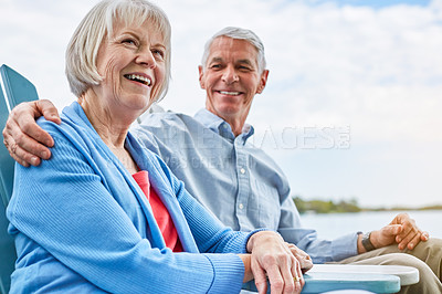 Buy stock photo Shot of an affectionate senior couple relaxing on chairs together outside