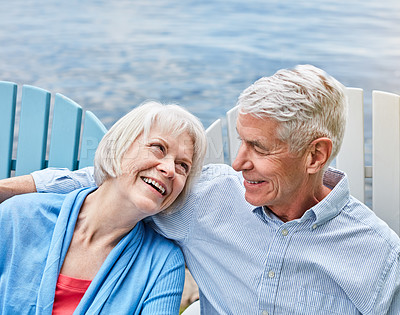 Buy stock photo Shot of an affectionate senior couple relaxing on chairs together outside