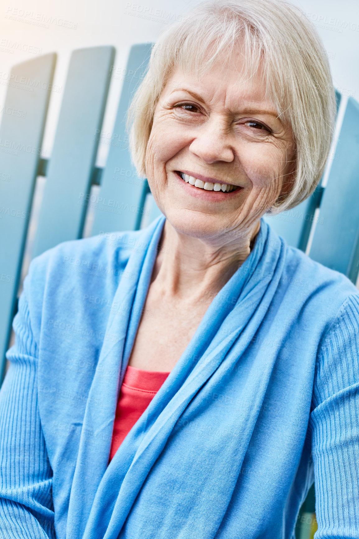 Buy stock photo Portrait of a happy senior woman relaxing on a chair outside