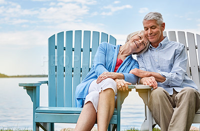 Buy stock photo Shot of an affectionate senior couple relaxing on chairs together outside