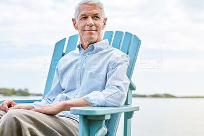 Buy stock photo Shot of a thoughtful senior man relaxing on a chair outside