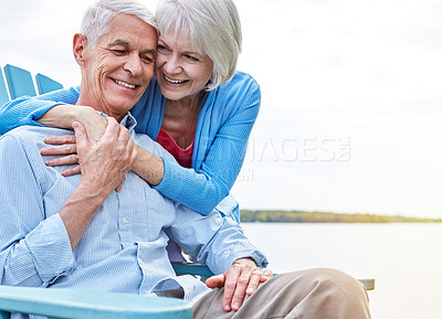 Buy stock photo Shot of an affectionate senior couple relaxing on chairs together outside