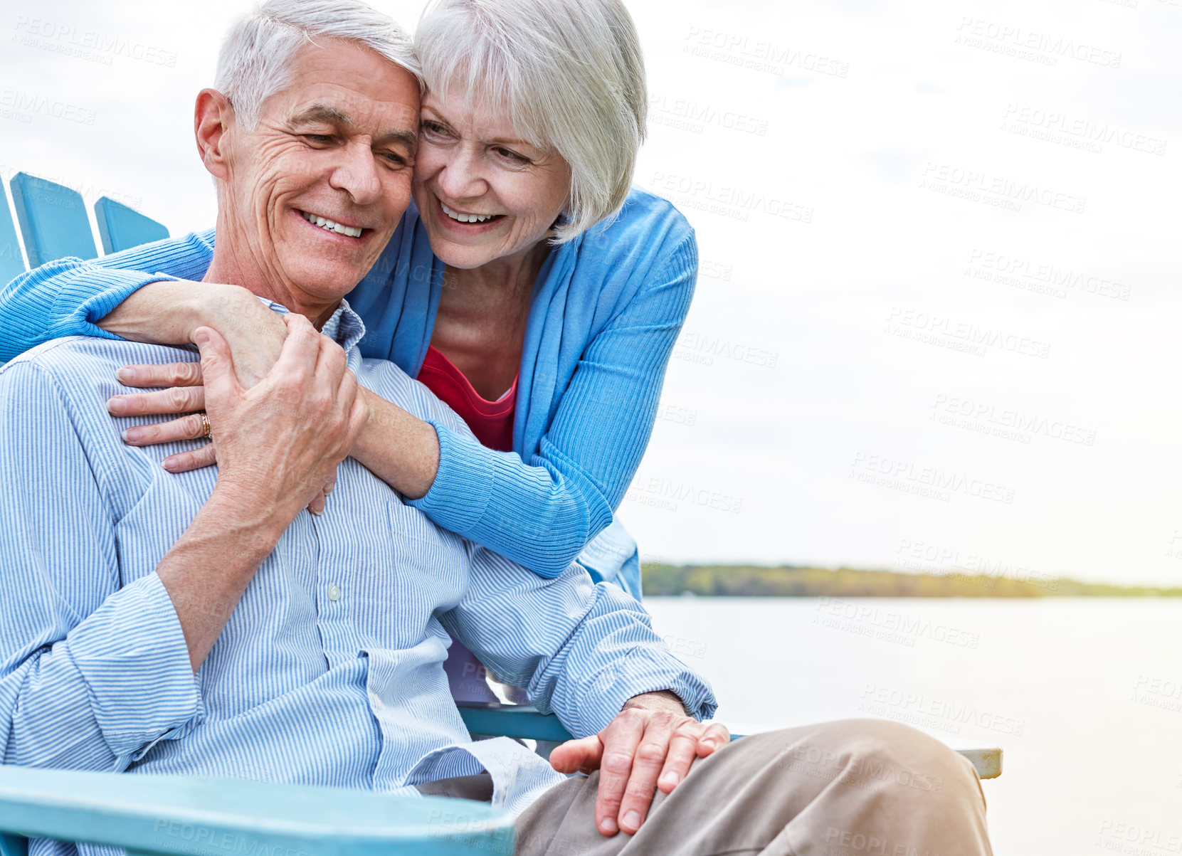 Buy stock photo Shot of an affectionate senior couple relaxing on chairs together outside