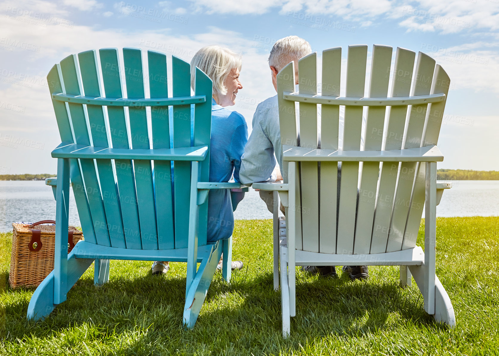 Buy stock photo Shot of an affectionate senior couple relaxing on chairs together outside