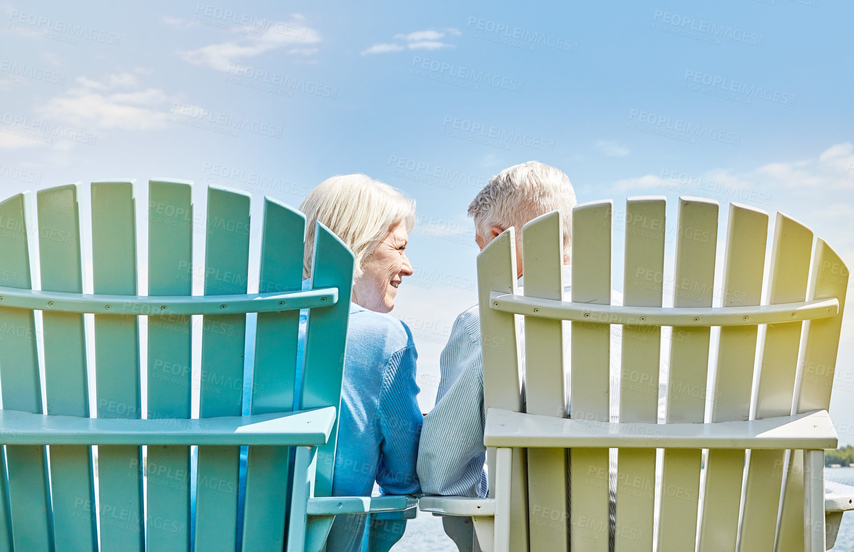 Buy stock photo Shot of an affectionate senior couple relaxing on chairs together outside