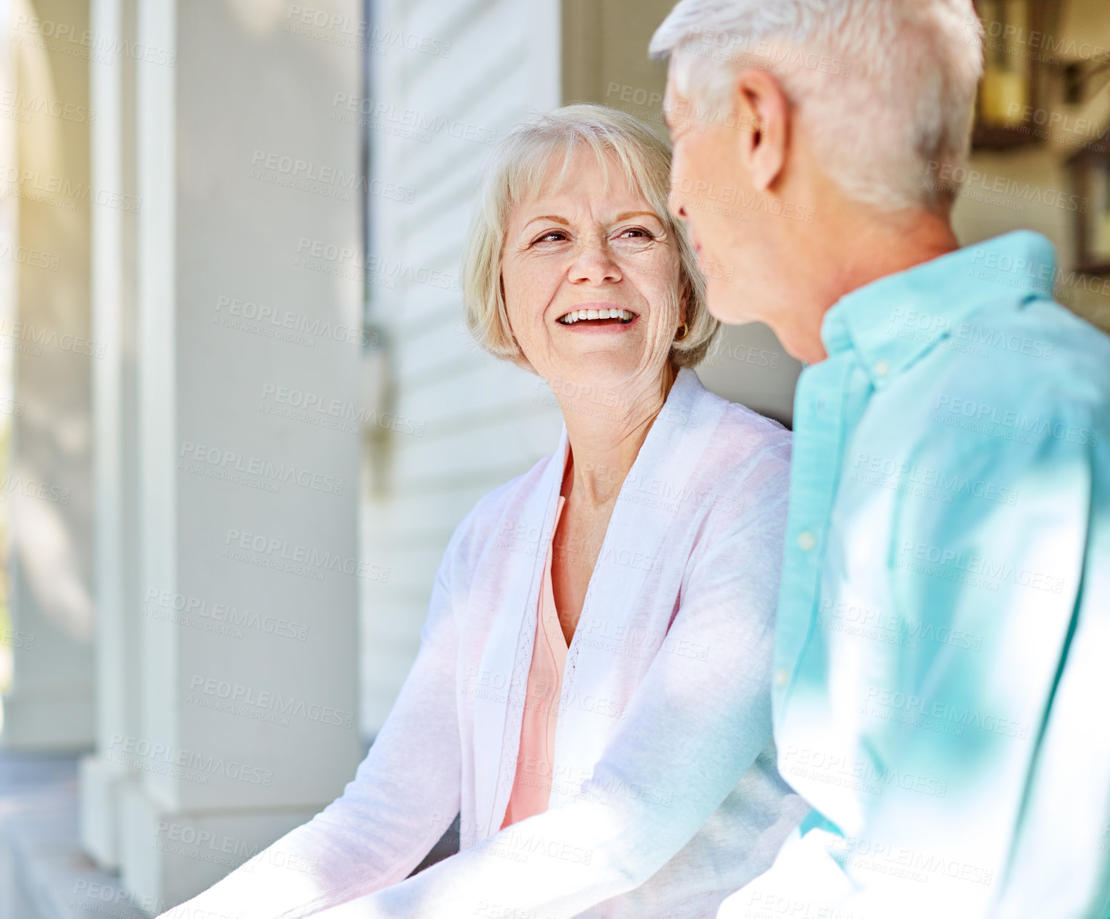 Buy stock photo Cropped shot of an affectionate senior couple sitting outside on their porch during the summer