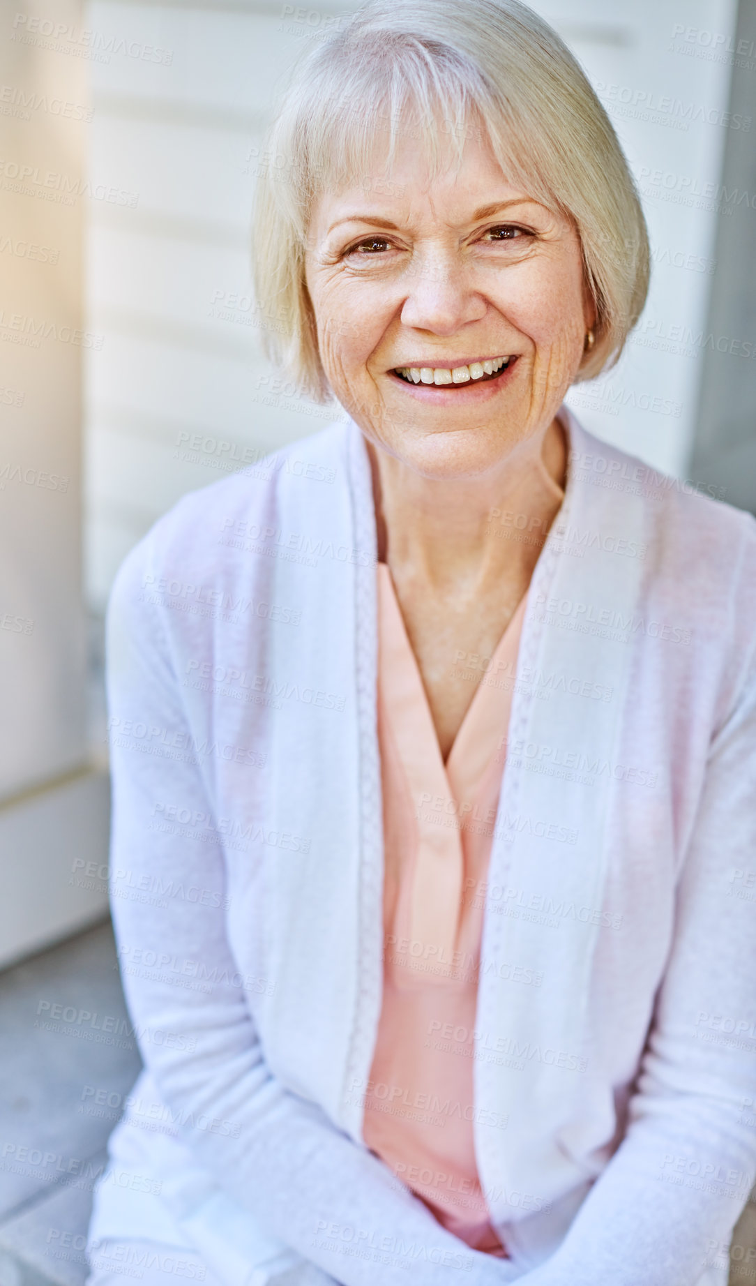 Buy stock photo Cropped portrait of a senior woman sitting on her porch during the summer