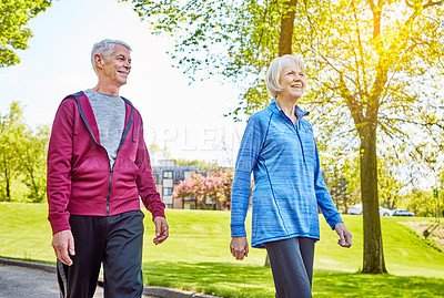 Buy stock photo Cropped shot of an affectionate senior couple taking a walk in the park during the summer