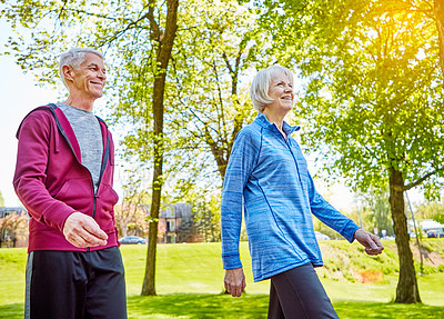 Buy stock photo Cropped shot of an affectionate senior couple taking a walk in the park during the summer